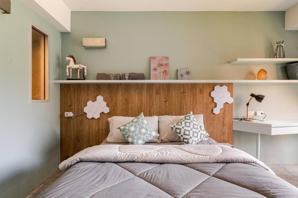 a bedroom with a bed with a wooden headboard at Dreamcatcher Condo/ Replay Condominium in Bophut 