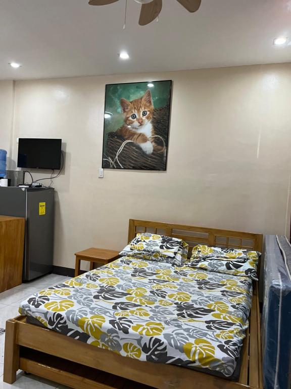 een slaapkamer met een bed met een kattenfoto aan de muur bij Albur Property Rentals in Alburquerque