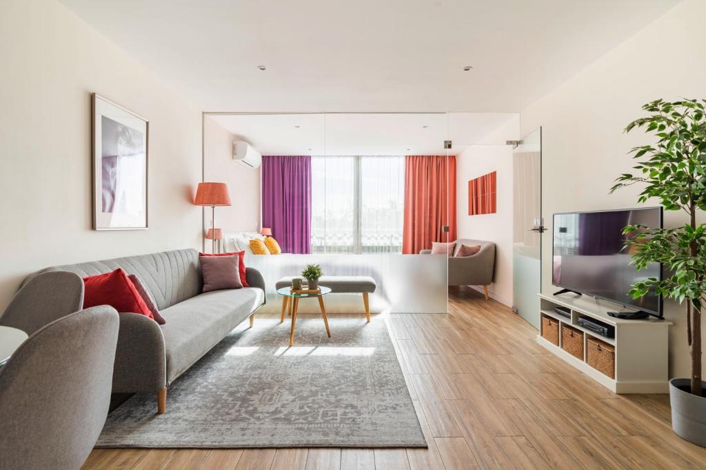 ein Wohnzimmer mit Sofa und Fernseher in der Unterkunft CASA JOY Vilamoura apartment in Vilamoura