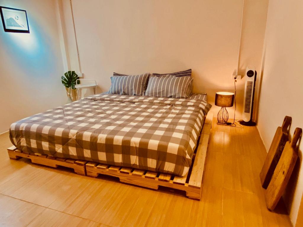 ein Schlafzimmer mit einem Bett mit einer karierten Decke in der Unterkunft Pai Casita in Pai