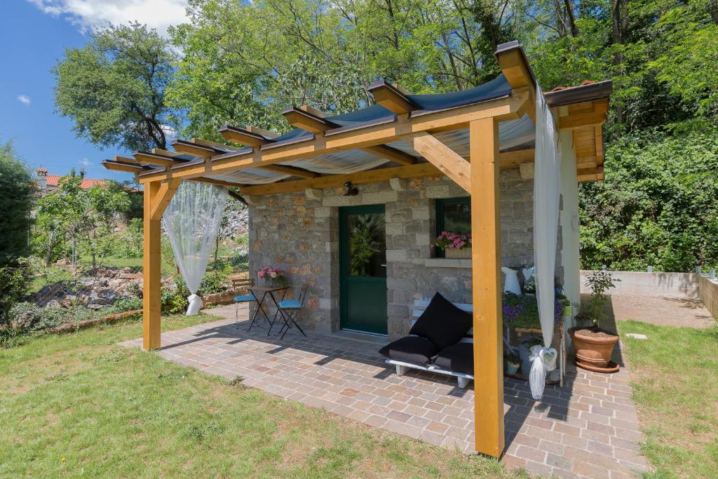 a wooden pergola with a couch under it at 9b-The Tiny House in Sežana