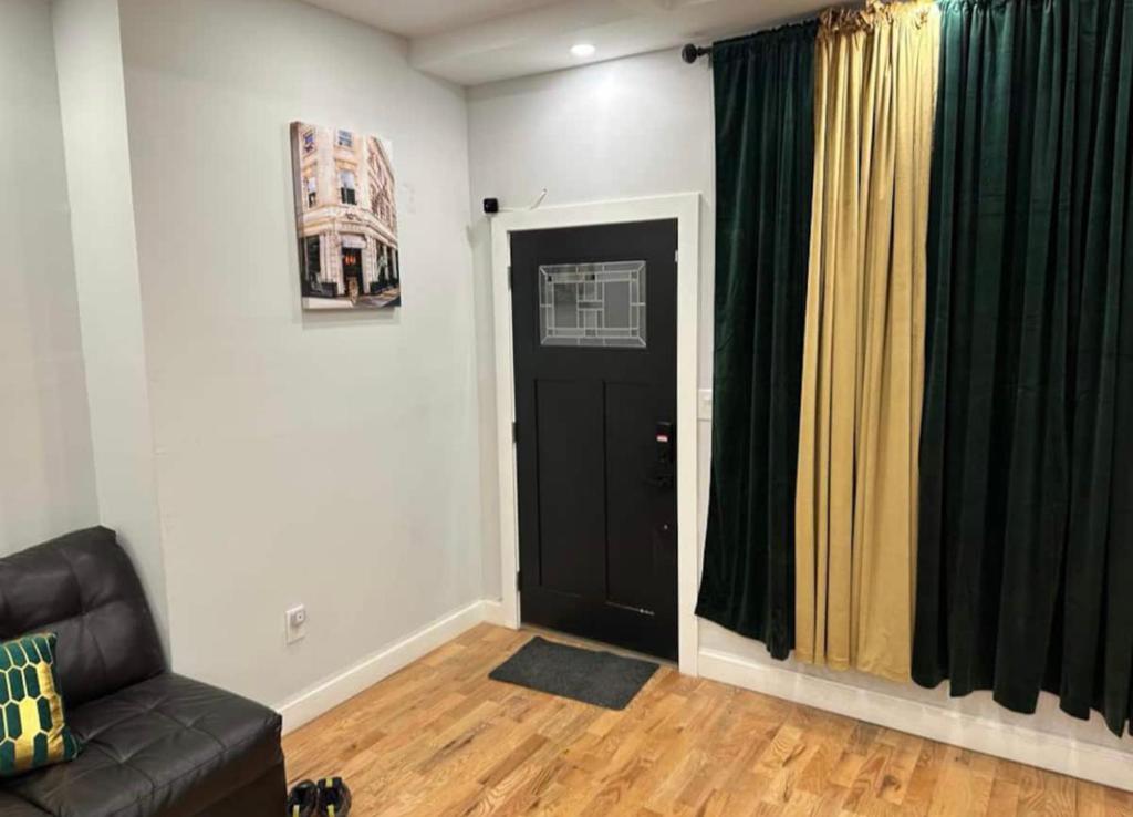 a living room with a black door and a couch at STEPH VACATION HOME in Brooklyn