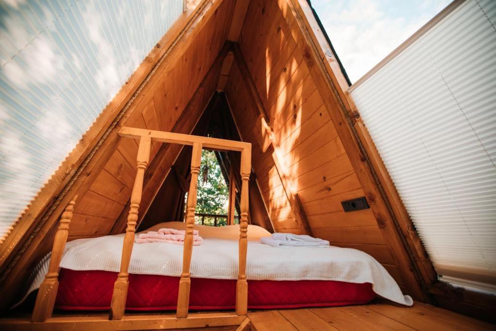 Oruba bungalov في ريزي: سرير في غرفة صغيرة في منزل خشبي