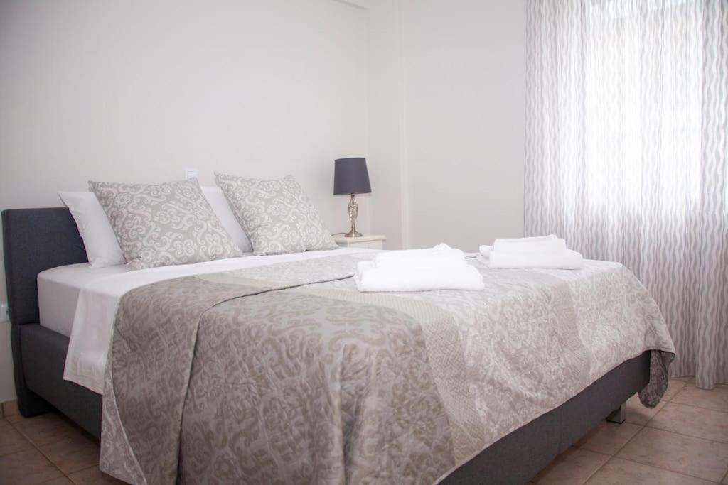 um quarto branco com uma cama grande e um cobertor em Olive House em Kalamata