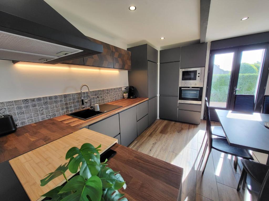 een keuken met een wastafel en een tafel. bij La maison des vacances 8 personnes in Ghyvelde