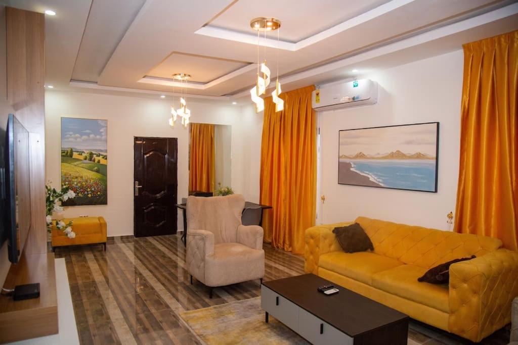 sala de estar con sofá amarillo y silla en Big chill stays en Ho