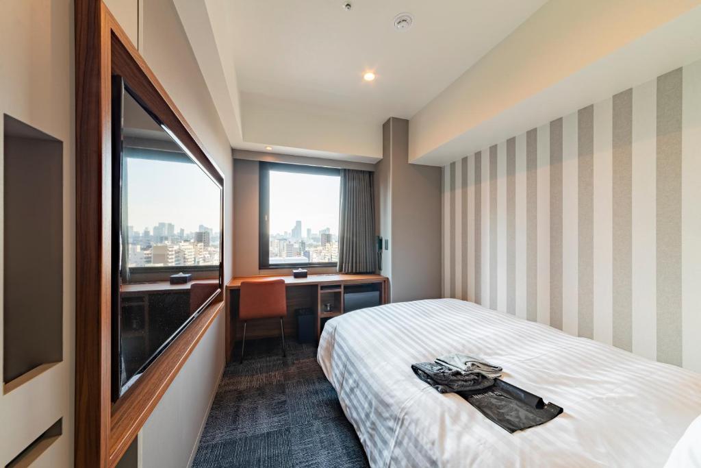 Postel nebo postele na pokoji v ubytování Via Inn Prime Osaka Kyobashi