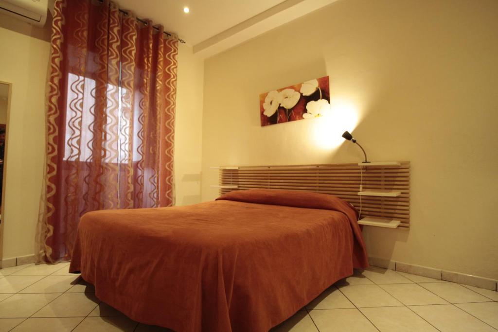 1 dormitorio con cama, lámpara y ventana en Vesta-Apartments, en Catania