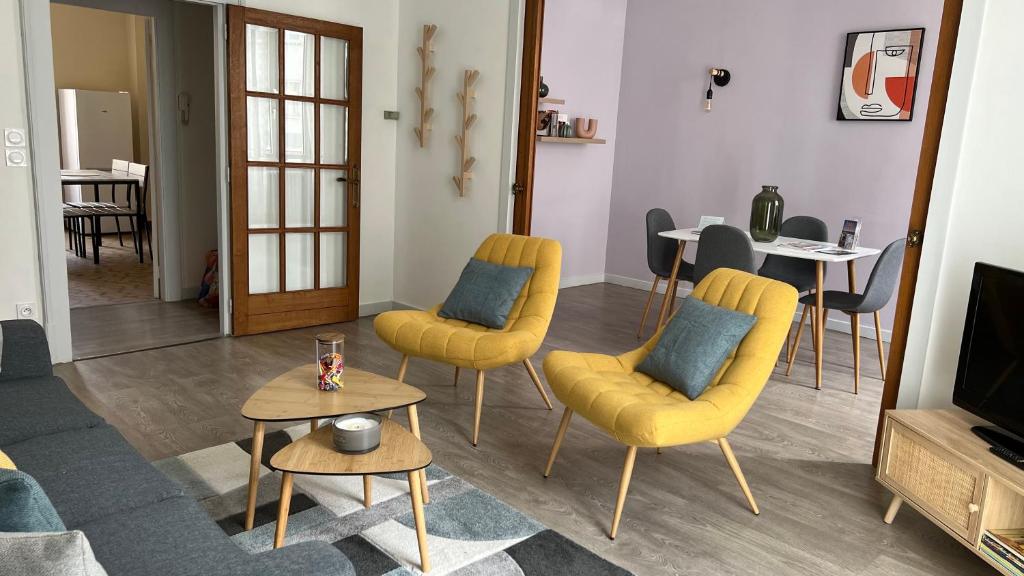 sala de estar con sillas amarillas y TV en Appartement T4 70m2 - meublé - centre ville - proche Thermes, en Lons-le-Saunier