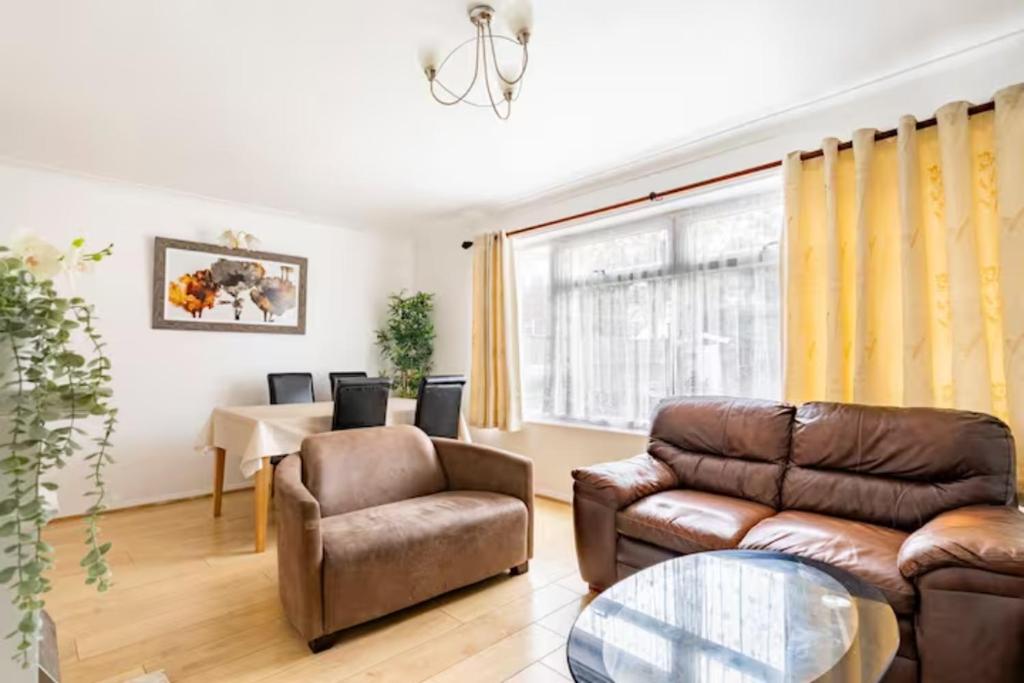 a living room with a couch and a chair and a table at Beaconsfield 4 Bedroom House in Quiet and a very Pleasant Area, Near London Luton Airport with Free Parking, Fast WiFi, Smart TV in Luton