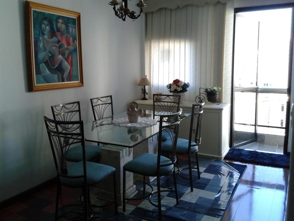 una sala da pranzo con tavolo in vetro e sedie di Hosts in Rio Homestay a Rio de Janeiro