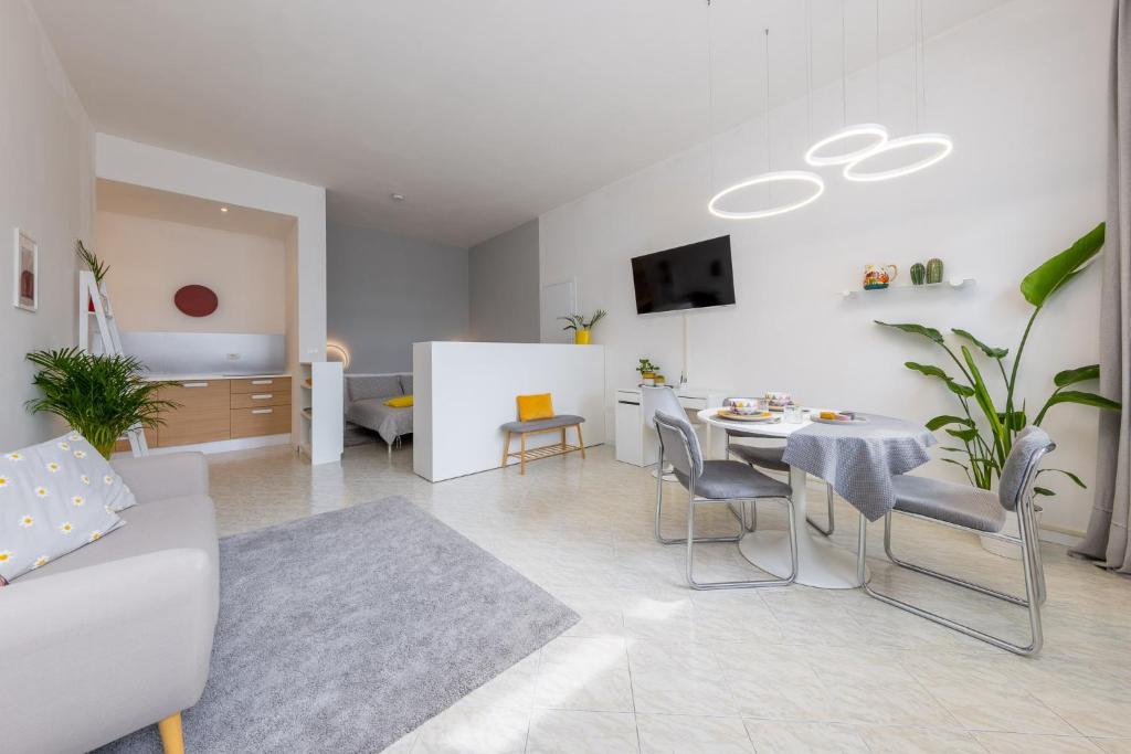 a living room with a table and a dining room at Top located 50m from beach in Caorle