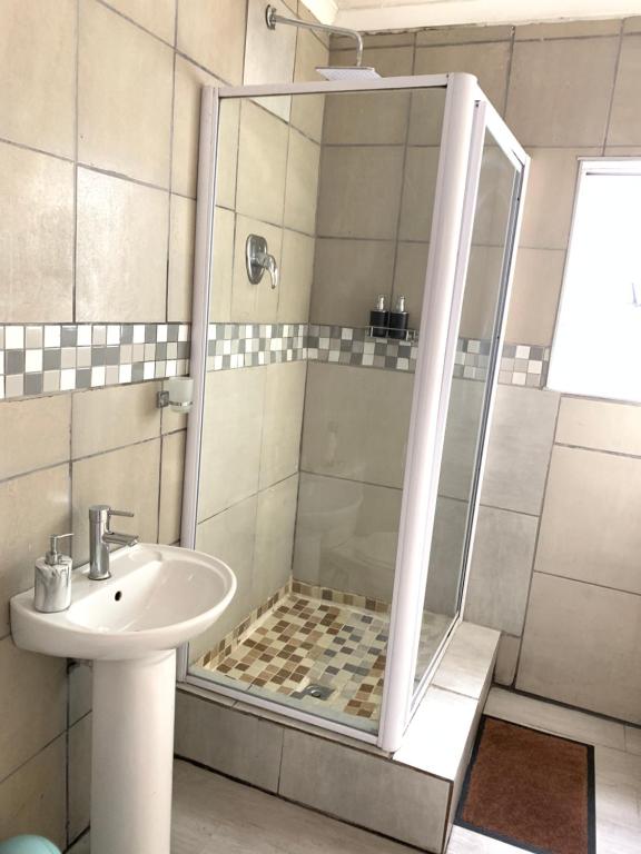 y baño con ducha y lavamanos. en Naliya Guest house en Ciudad del Cabo