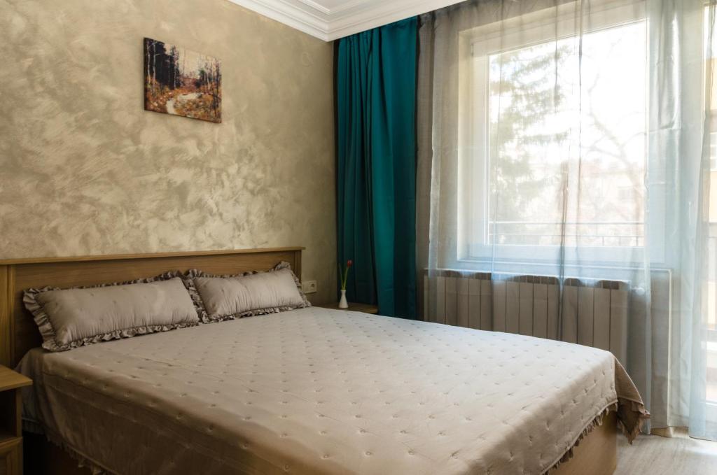 a bedroom with a large bed with a window at COOP Apartments, Sofia in Sofia