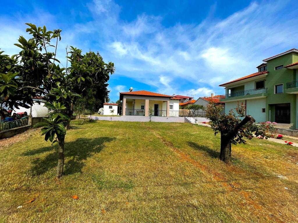a yard with two trees in front of a house at 2-Bedroom Luxury Family Home in Flogita