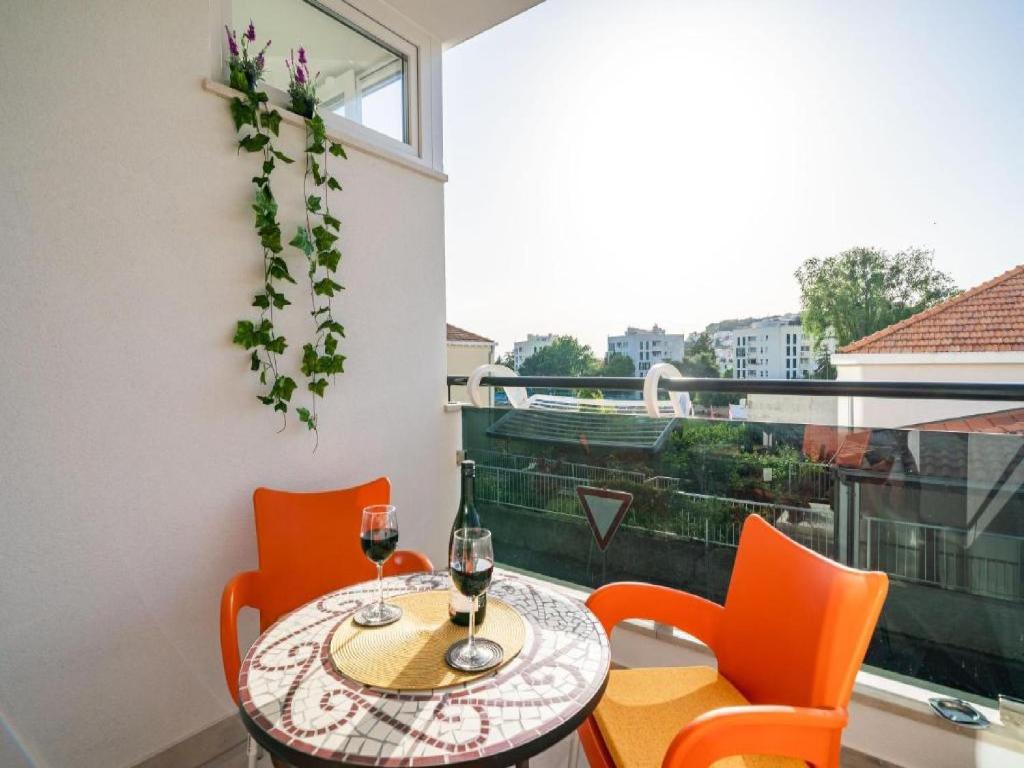 a table with two glasses of wine on a balcony at Apartment Anka in Dubrovnik