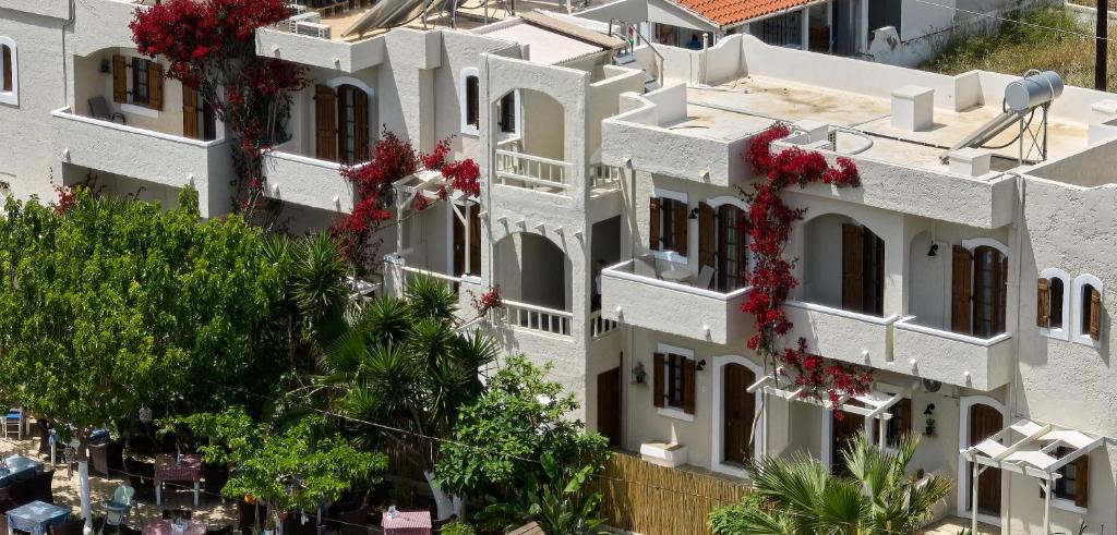 - une vue sur un bâtiment blanc orné de fleurs rouges dans l'établissement Mila Malia Studios Hotel, à Mália