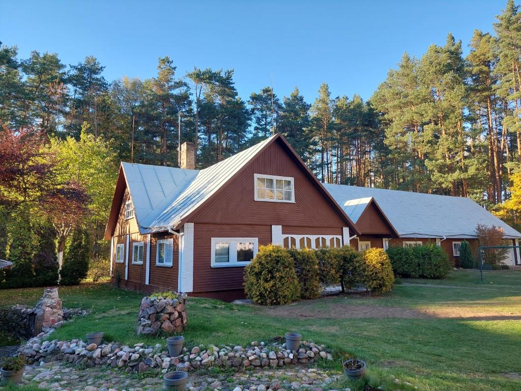 uma casa com um telhado de gambrel num quintal em Aido ir Jovitos sodyba Jorunas em Kernavė