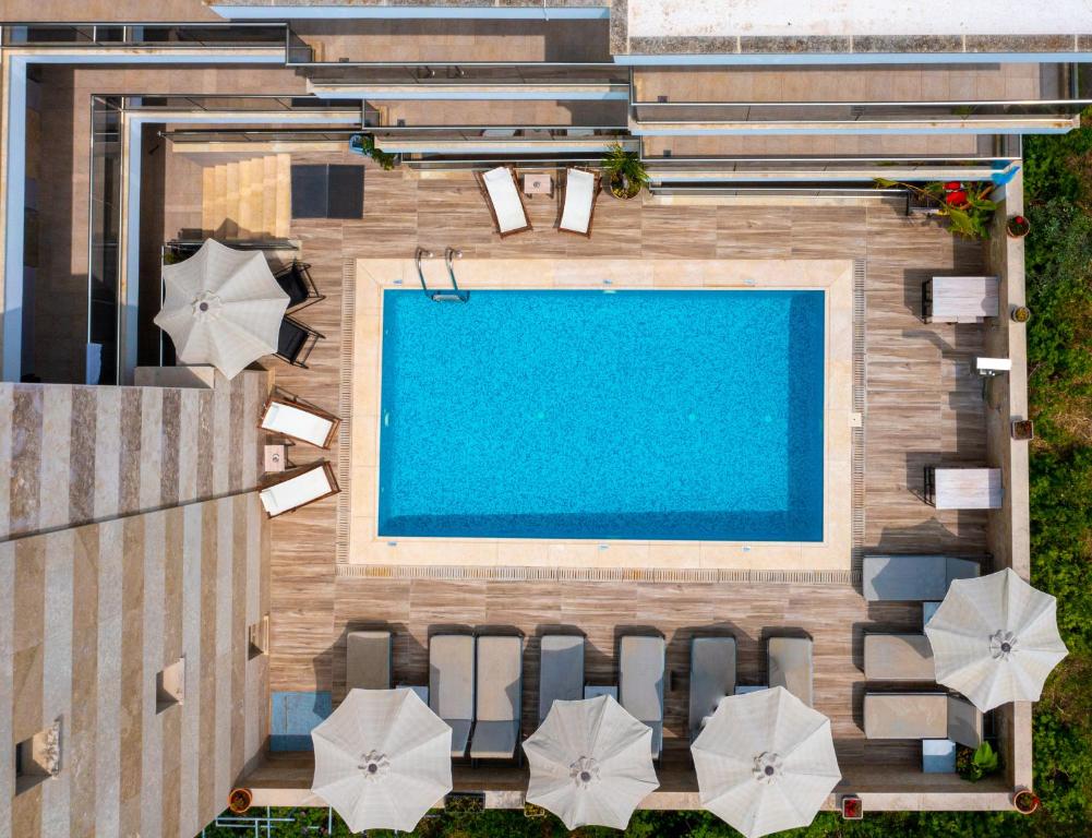 uma vista superior para uma piscina com cadeiras e guarda-sóis em Vellum Luxury Living em Kallithea Halkidikis