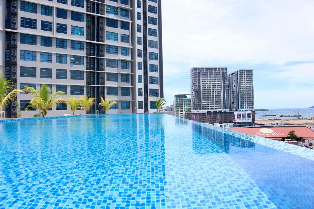 a large swimming pool in a city with tall buildings at Homesuite' Home at Jesselton Quay in Kota Kinabalu