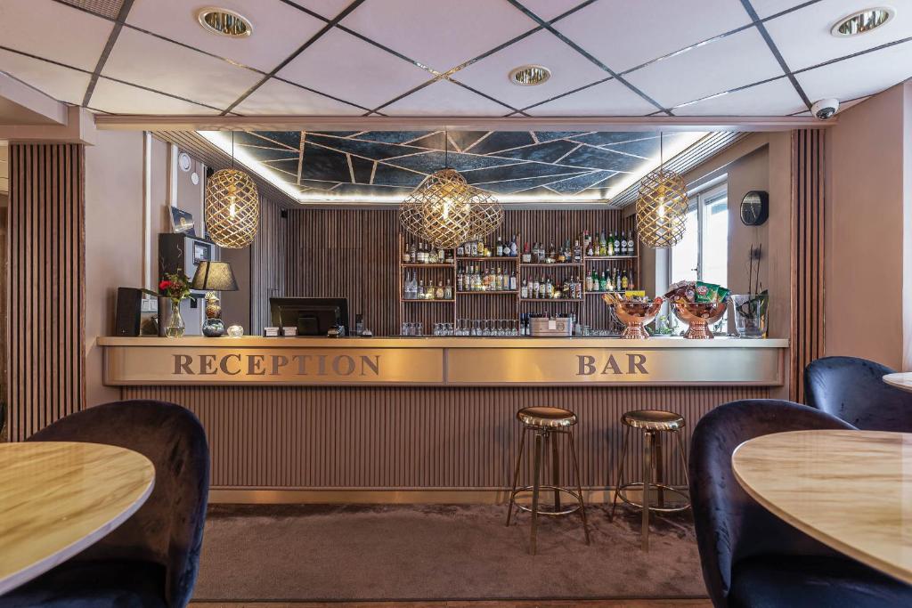 a bar in a restaurant with tables and stools at Hotell Arkad in Västerås