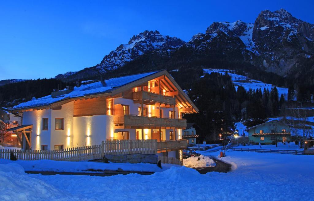 a house in the snow in front of a mountain at Tarlack Appartements Hütten 1a in Leogang