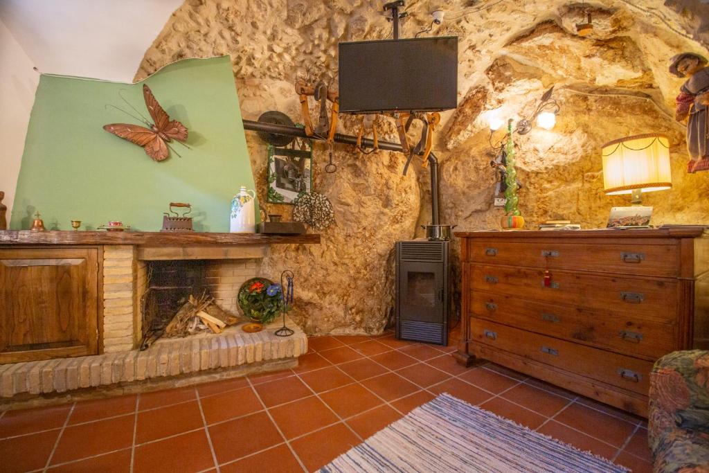 a living room with a fireplace in a stone wall at CASA Flag Tur in Castel del Monte