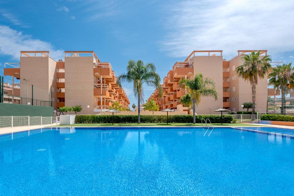 a large blue swimming pool in front of buildings at Lopimar Exclusivo in Canet de Berenguer