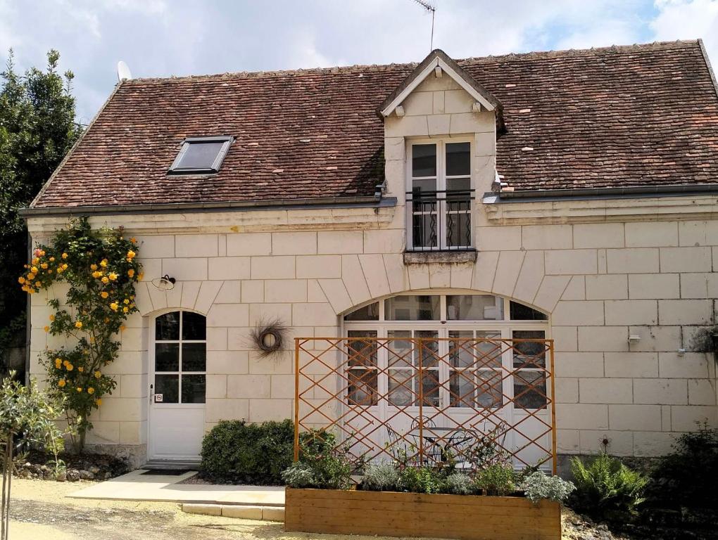 een wit huis met een bruin dak bij Le Gîte des Marguerites in Montrichard
