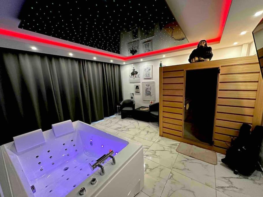 a room with a bath tub with purple lighting at Cozy Rental SPA in Schiltigheim