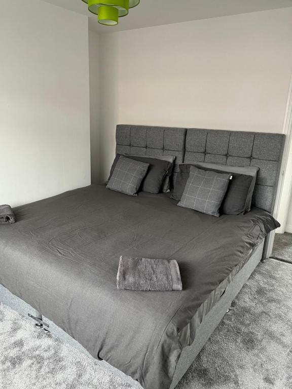 a large bed in a bedroom with a gray bedspread at Stylish Modern 2 Bed House, St Helens in Saint Helens