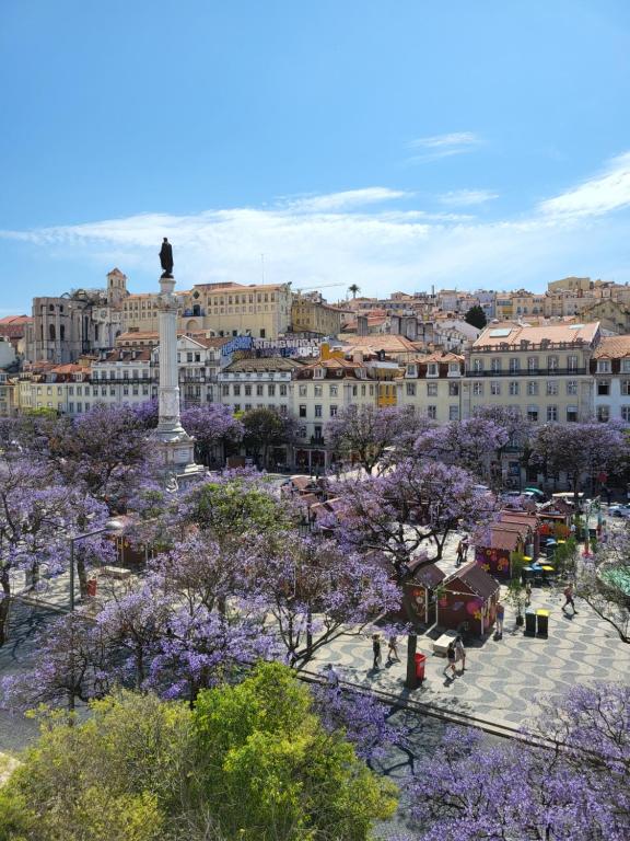 a view of a city with purple trees and buildings at Liberator Rossio in Lisbon