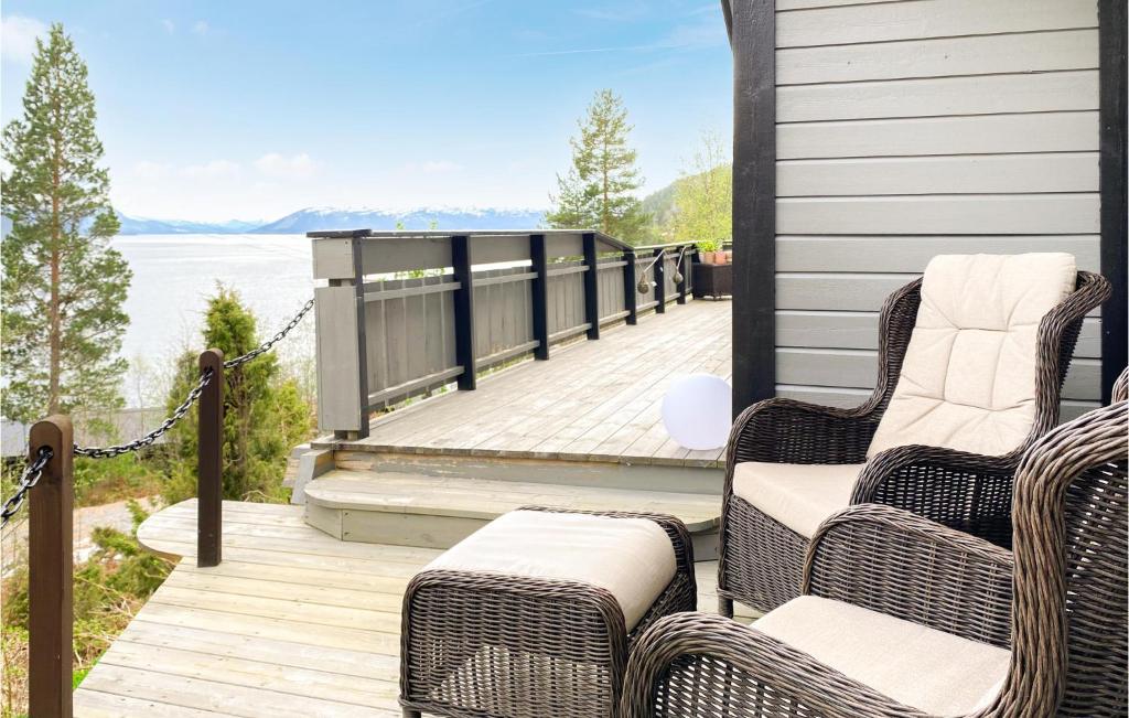 porche con sillas de mimbre y vistas al agua en Amazing Home In Bverfjord With Wifi And 2 Bedrooms, en Bø