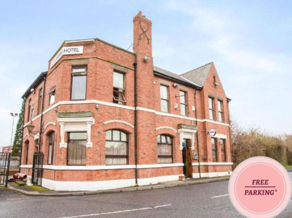 a brick building with a free parking sign in front of it at OYO The Rowers Hotel, Dunston Gateshead in Newcastle upon Tyne