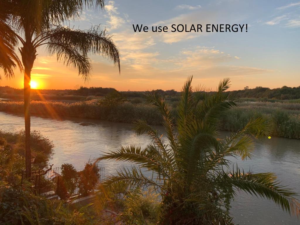 a sunset over a river with the words we use solar energy at Le Must Residence in Upington
