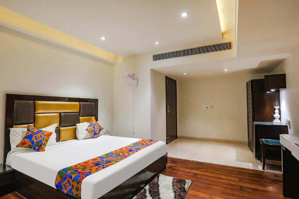 um quarto com uma cama grande num quarto em FabHotel Grand Stay em Nova Deli