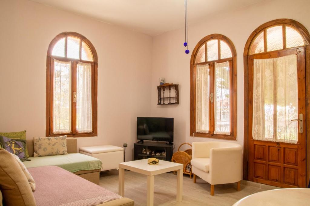 sala de estar con 2 ventanas arqueadas y sofá en Deta, en Ildir