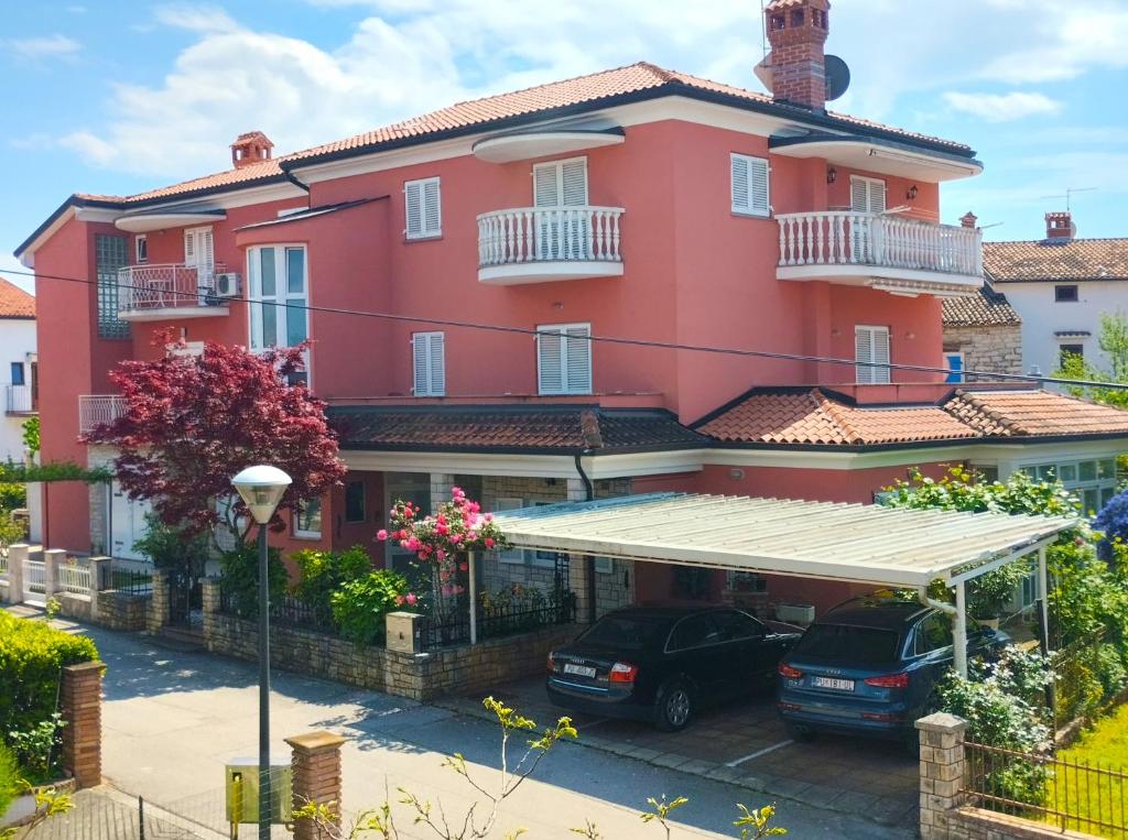 un edificio rojo con coches estacionados frente a él en Apartment Danica 356, en Umag