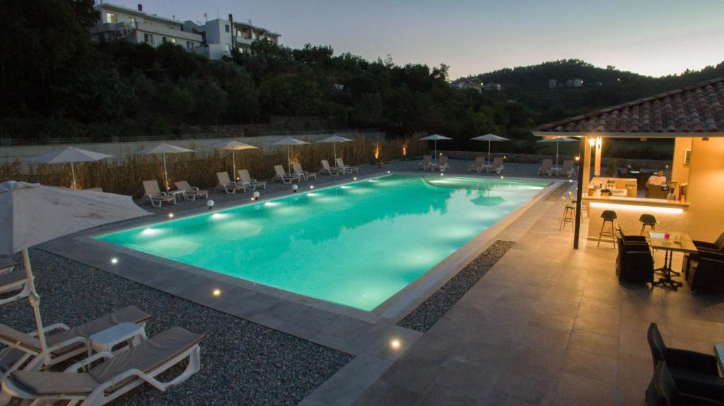 a large swimming pool with chairs and umbrellas at La Hacienda in Ulcinj