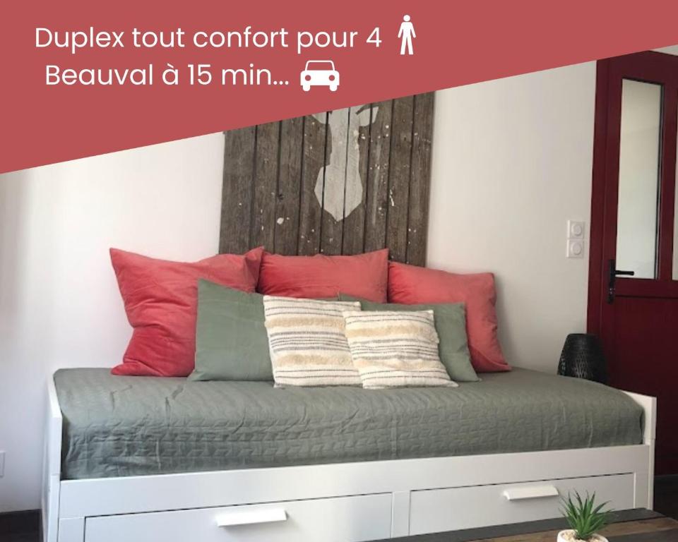 a bed with red and green pillows in a bedroom at Duplex/Beauval & Châteaux in Selles-sur-Cher