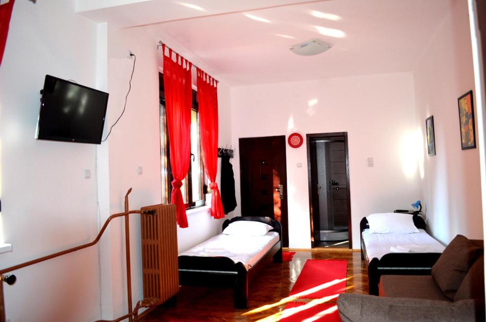 a living room with two beds and a flat screen tv at Apartmants Night Lux in Niš
