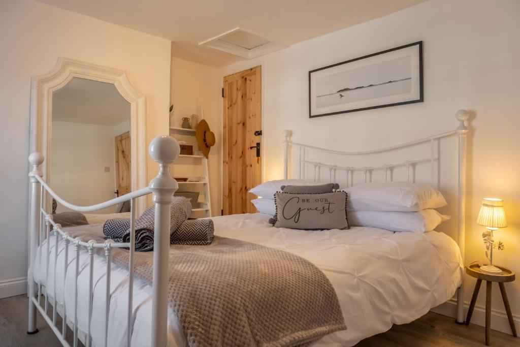 1 dormitorio con 2 camas y espejo en Eden Cottage en Wells next the Sea