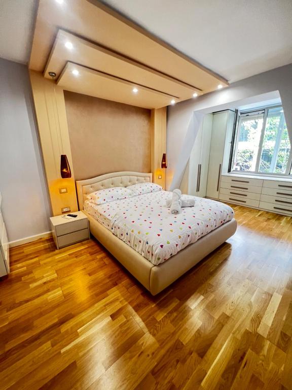 Cama grande en habitación con suelo de madera en Tirana center en Tirana