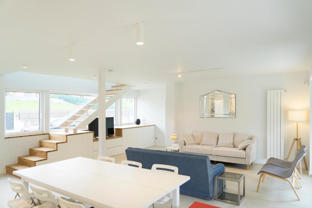 a living room with a table and chairs and a couch at Villa El Rodal in Pontones