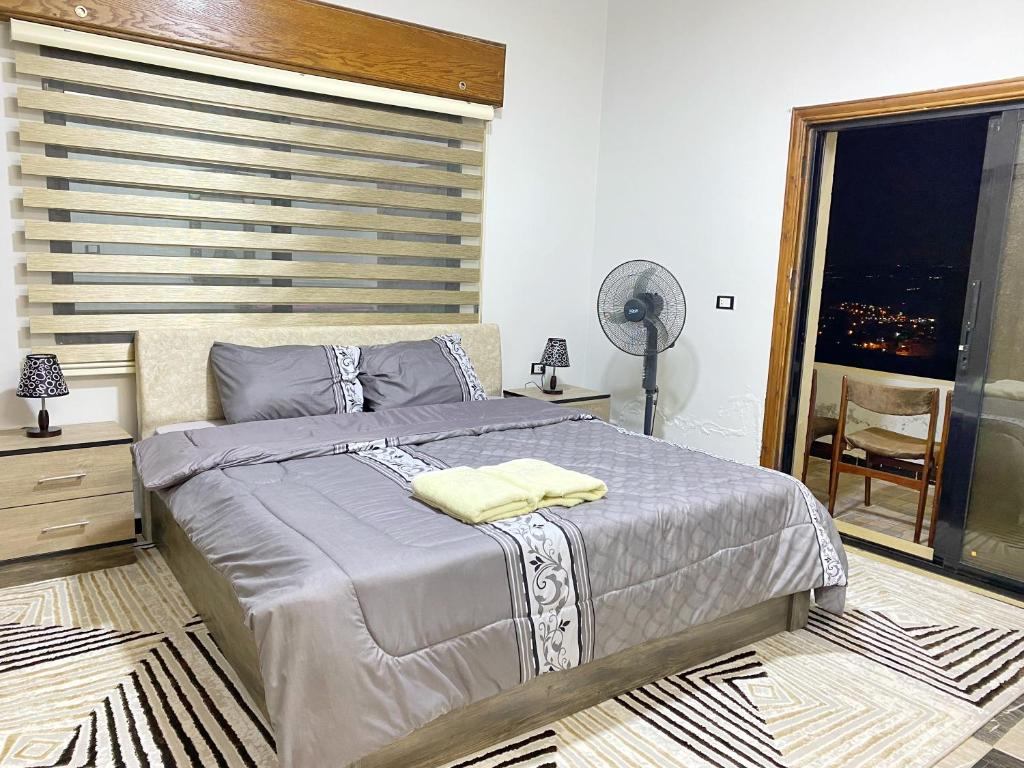 a bedroom with a large bed with a large window at Jasmine's House in Jerash
