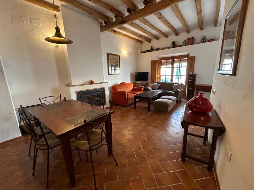 sala de estar con mesa y chimenea en Campanario 3, en Alájar