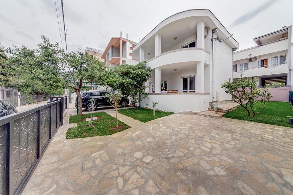 a white house with a fence and a driveway at Holiday Home Adria in Dobra Voda