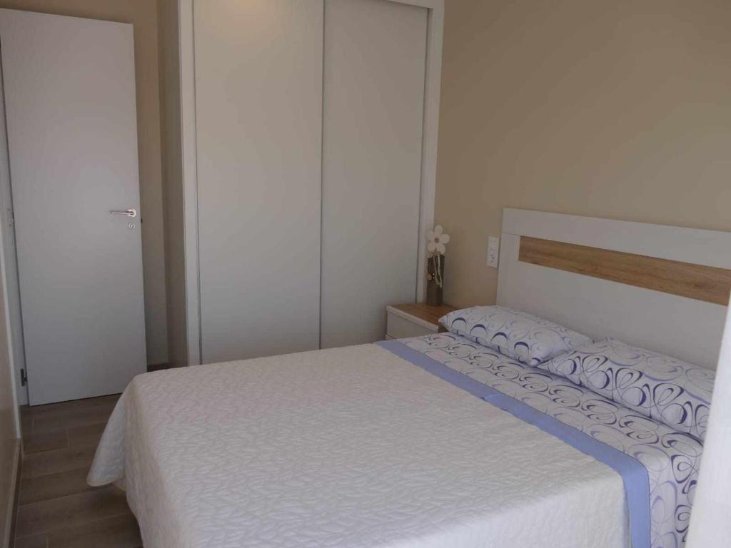 sypialnia z białym łóżkiem i niebieskim kocem w obiekcie Mediterrania Marina w mieście Puerto de Sagunto