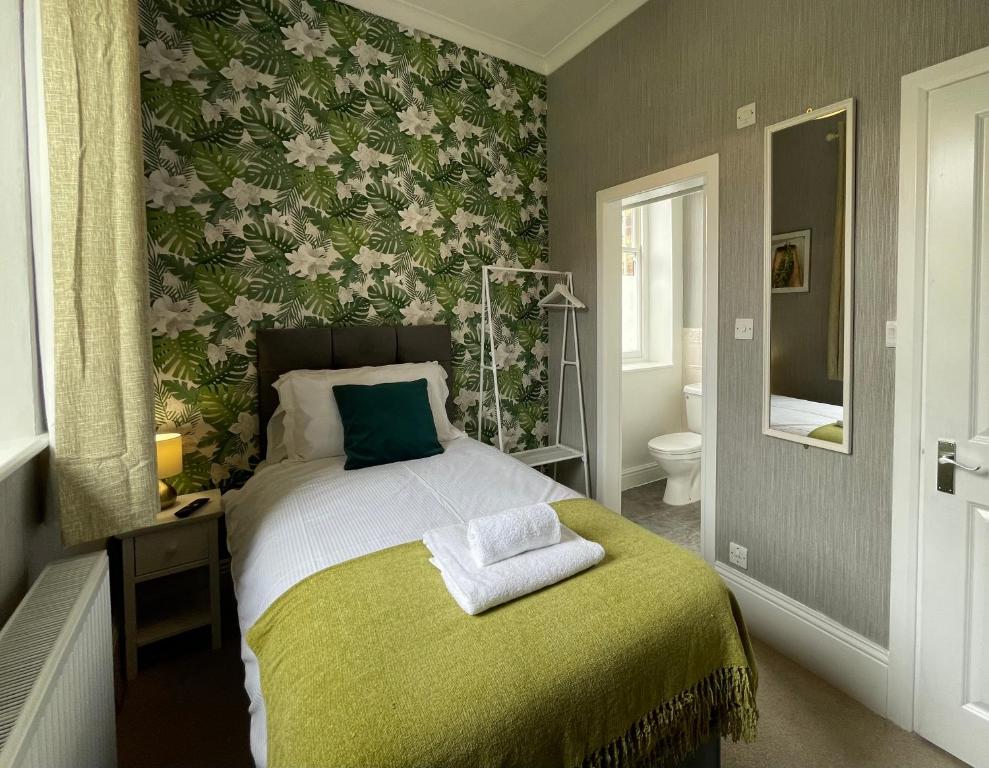 a bedroom with a bed with a green blanket at The Capsule in Keswick in Keswick