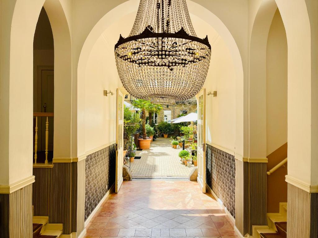 a large chandelier hangs from the hallway of a building at Garden Living - Boutique Hotel in Berlin